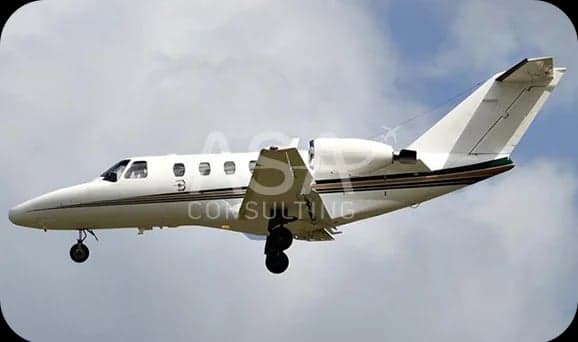 A white Cessna Citation jet in flight.
