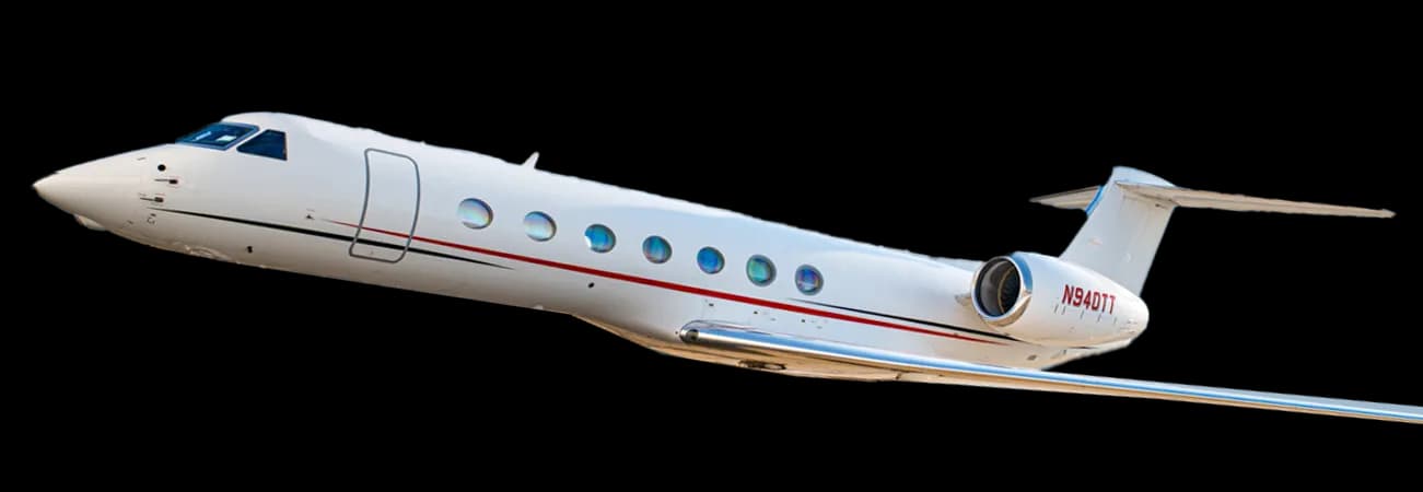 A luxurious aircraft interior with cream leather seats, polished wood tables, and a sushi plate.
