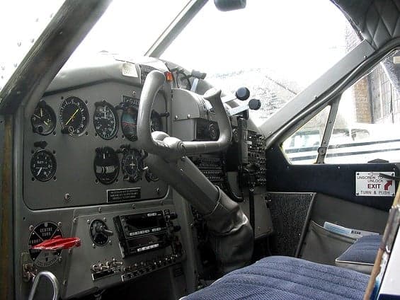 The cockpit of the aircraft features a gray instrument panel and blue seats.