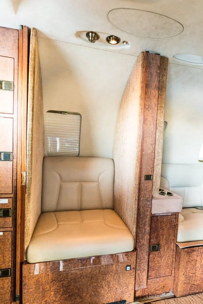 A view of the interior cabin of the aircraft, showing the seating arrangement and wood paneling.