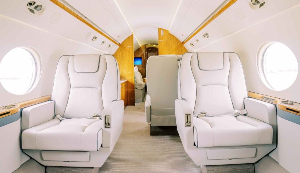 A white private jet with the door open and stairs extended.