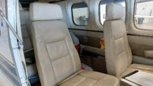Aircraft interior with two cream-colored leather seats.