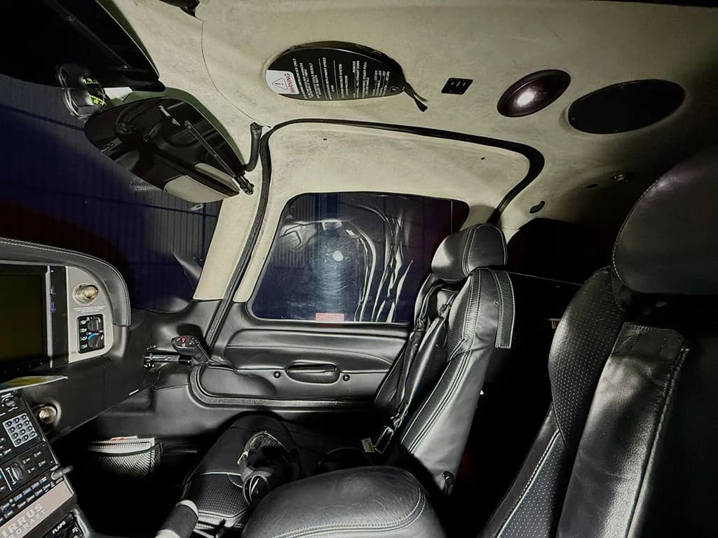 The black leather interior of a Cirrus SR22T cabin, showing the pilot and co-pilot seats and part of the dashboard.