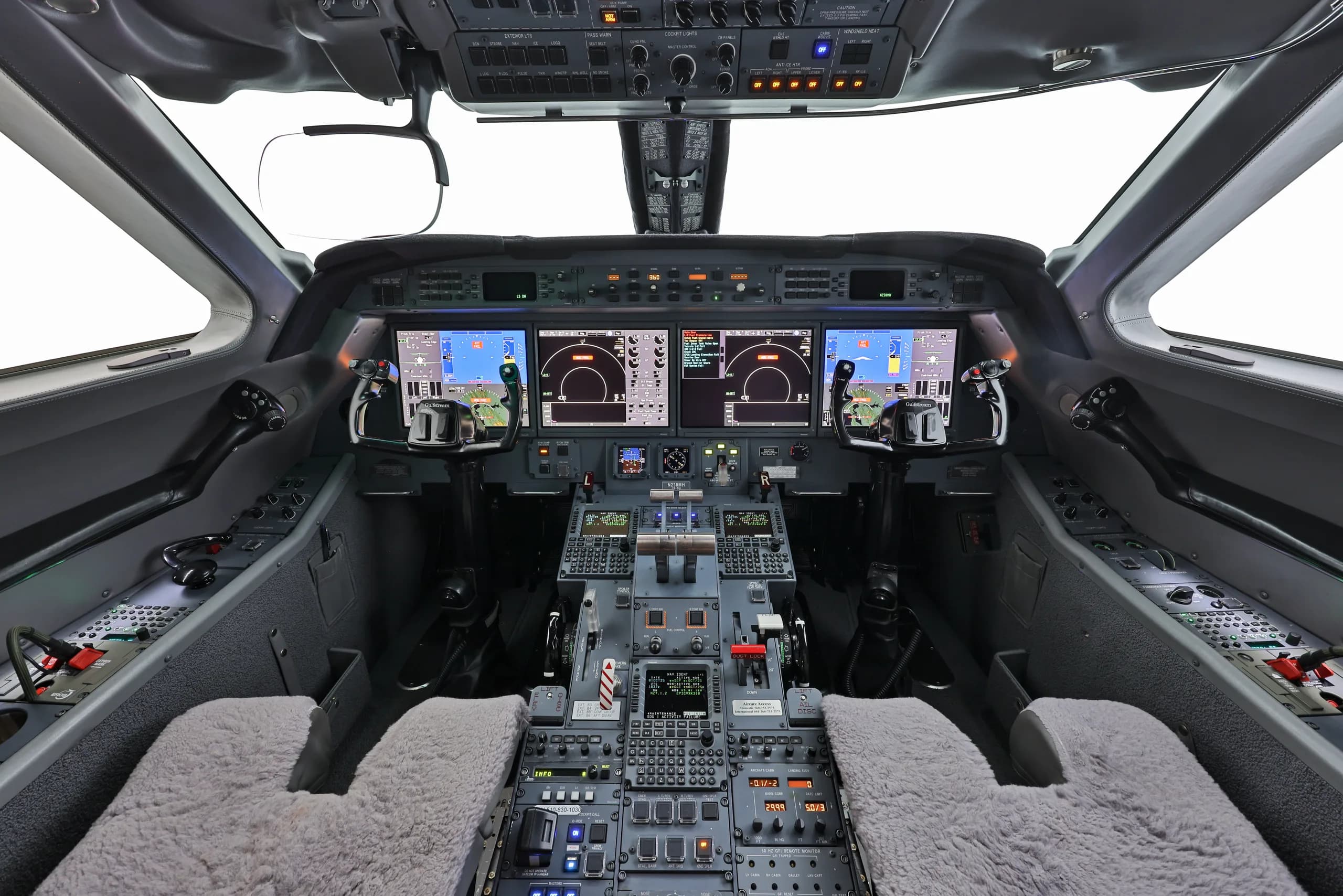 The modern cockpit of a private jet, featuring multiple digital displays and complex control panels.