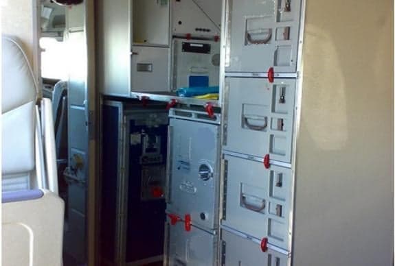 Interior view of aircraft galley with storage compartments.