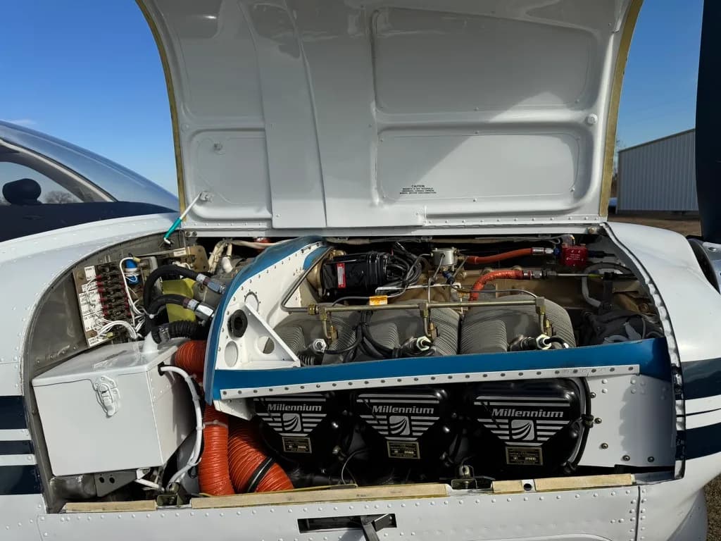 The engine compartment of the Beechcraft Bonanza with the cowling open.
