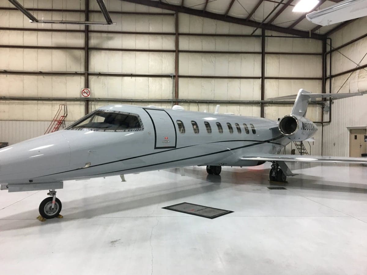 A gray aircraft, N800CH, is parked inside a hangar.