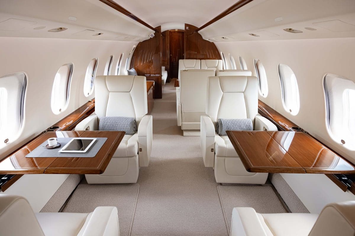 View of the aircraft interior with seats and tables.