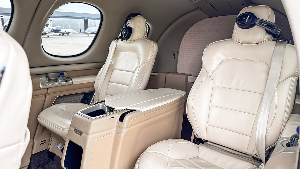The interior of the Cirrus Vision Jet features cream-colored leather seats and a center console.