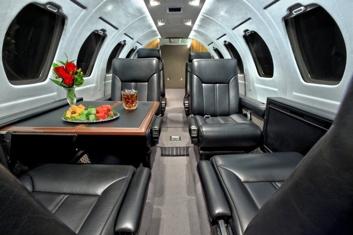 The interior of the Cessna Citation CJ1+ features a table with refreshments and leather seating.