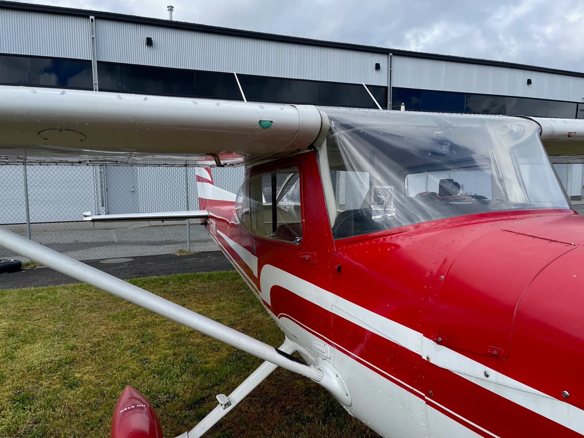 Close-up of the wing and fuselage of C-FDPS Cessna aircraft with red and white paint scheme.