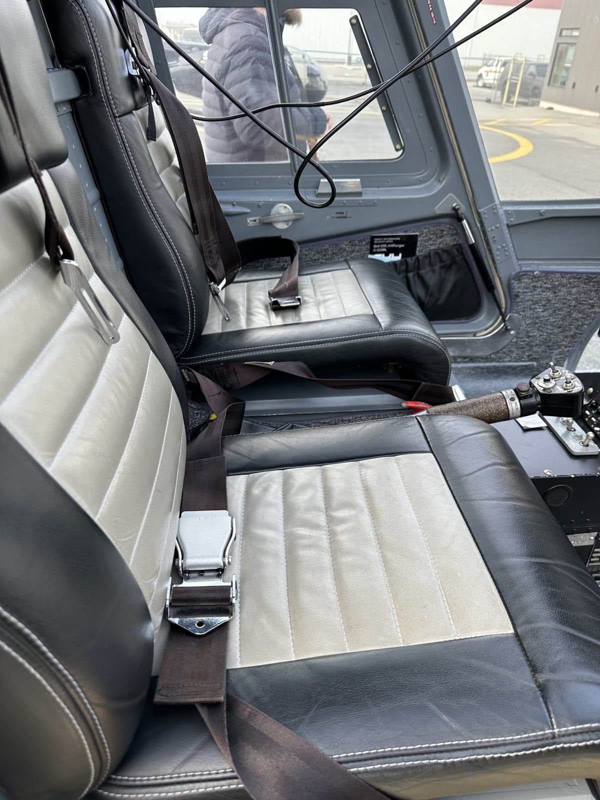 View of the cockpit of a helicopter, including the instrument panel and seats.