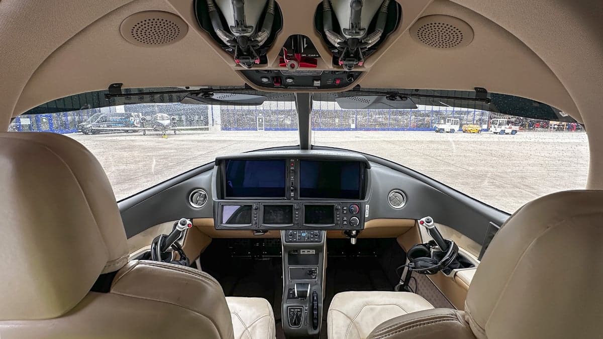 The cockpit of the Cirrus Vision Jet features a modern glass panel and cream-colored leather seats.