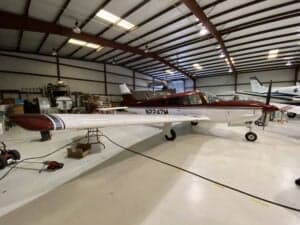 N2247M is shown in a hangar with a red and white paint scheme.