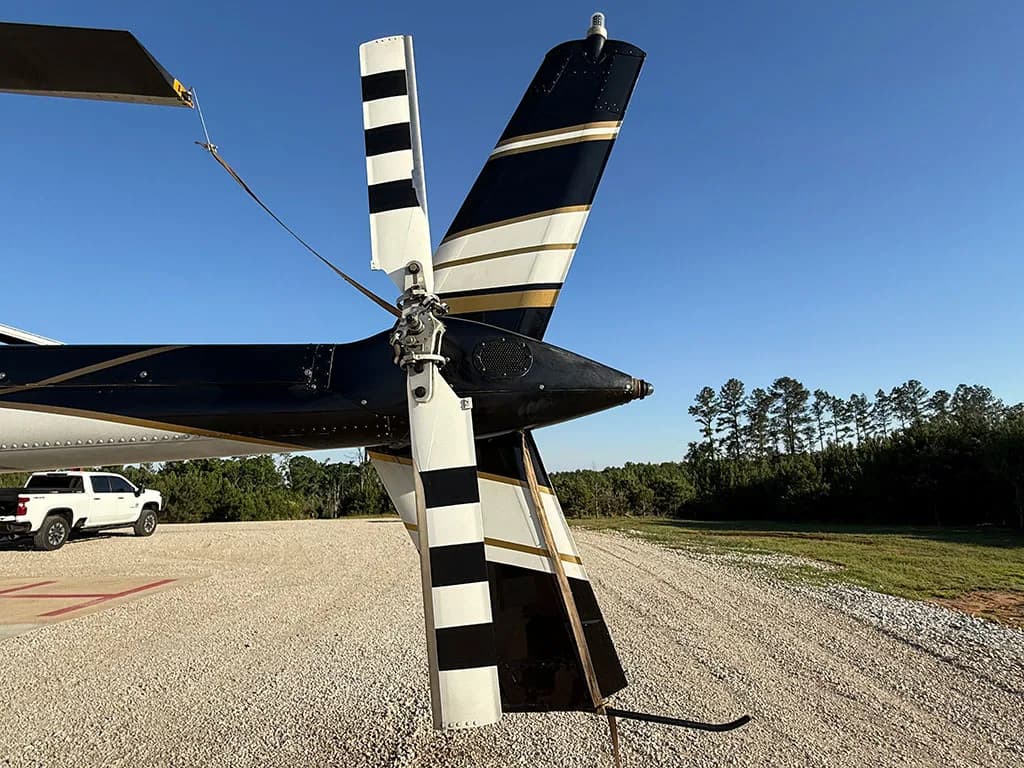 A close-up view of the black and white striped tail rotor and vertical stabilizer of the helicopter.