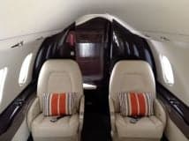 View of the aircraft's interior with two seats and striped pillows.