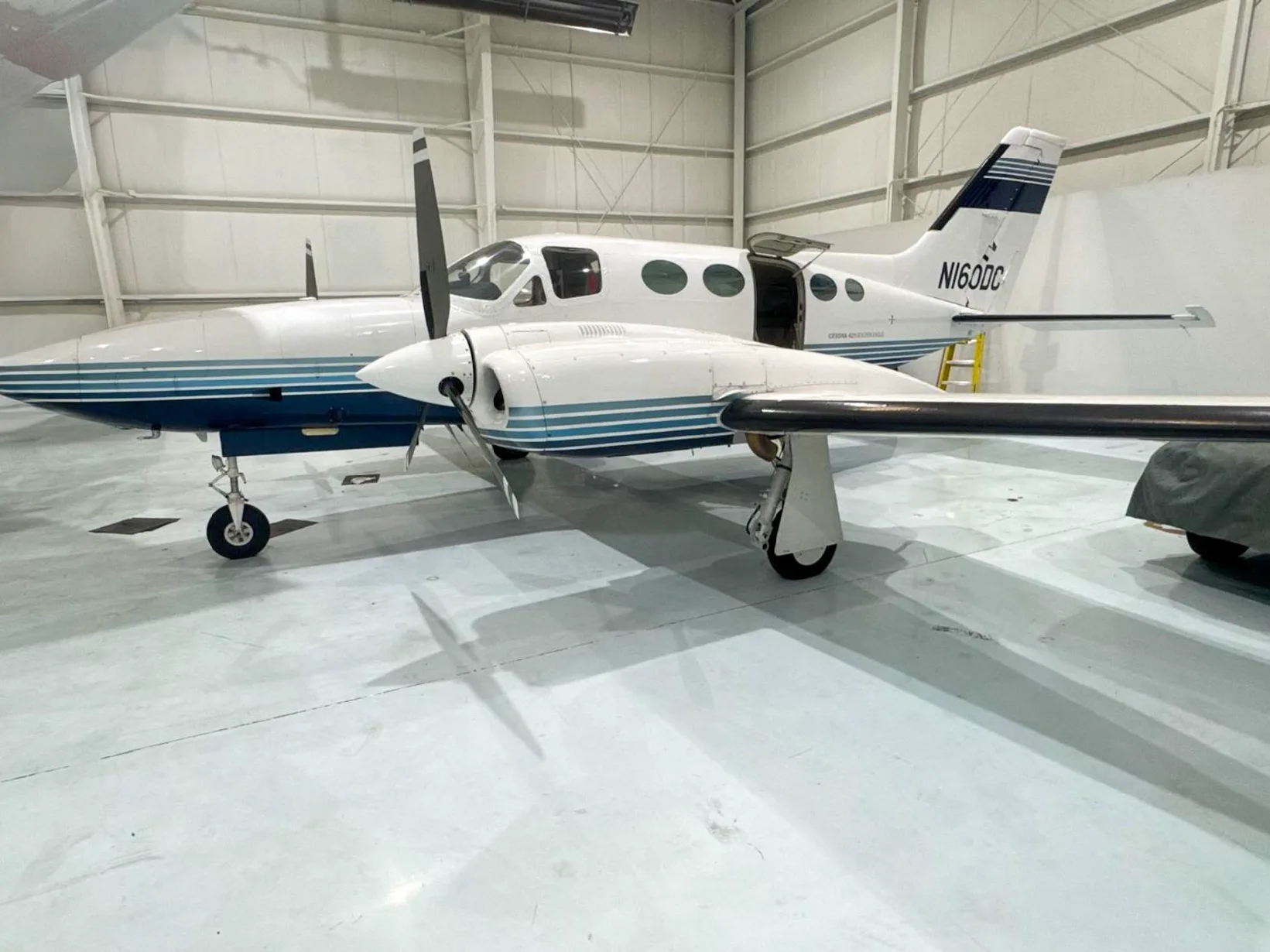 A Cessna 421 Golden Eagle with tail number N160DC parked in a hangar.