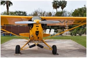 Yellow Piper Cub NC3561K parked on a concrete pad.