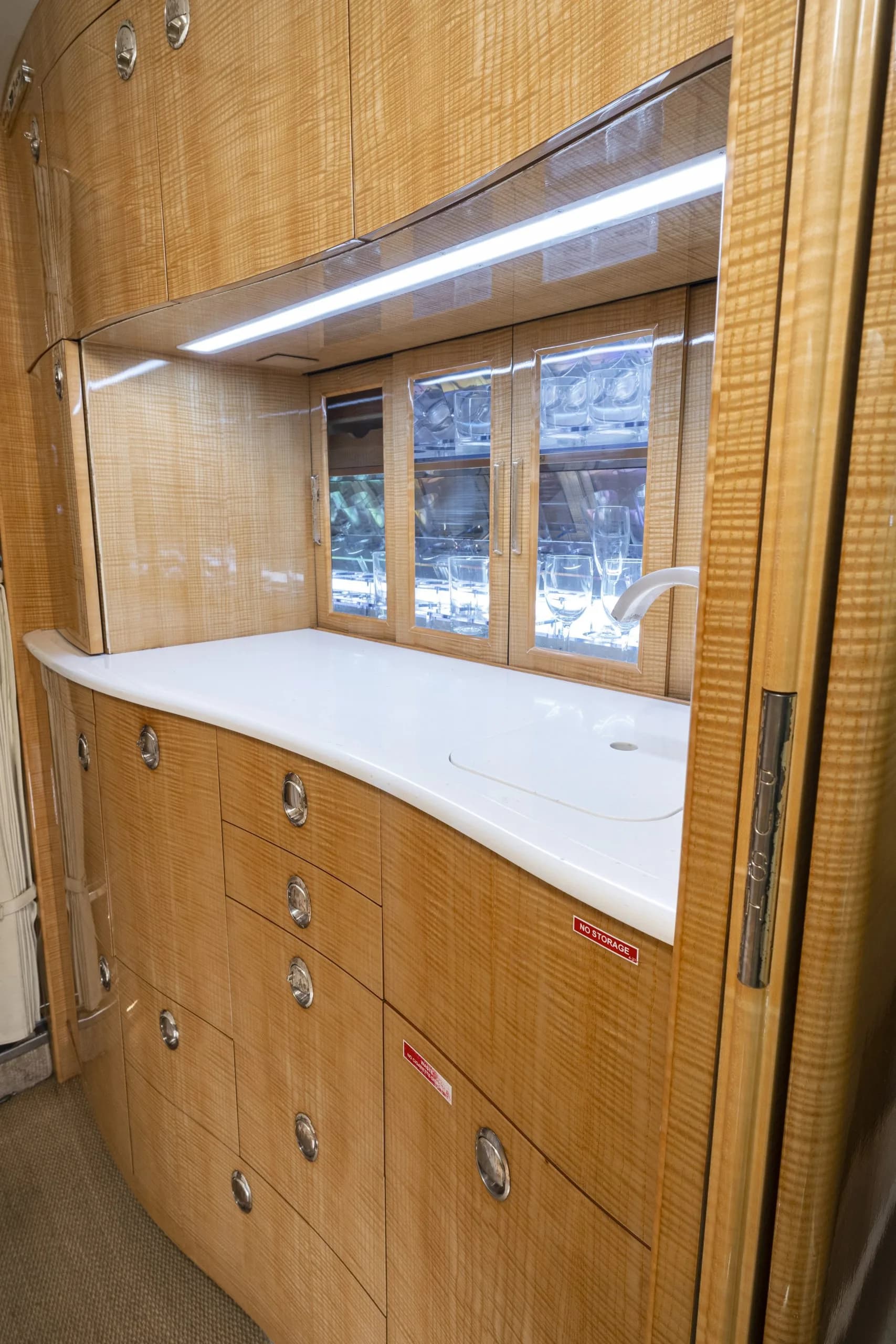 The aircraft's interior features a galley with a sink and storage.