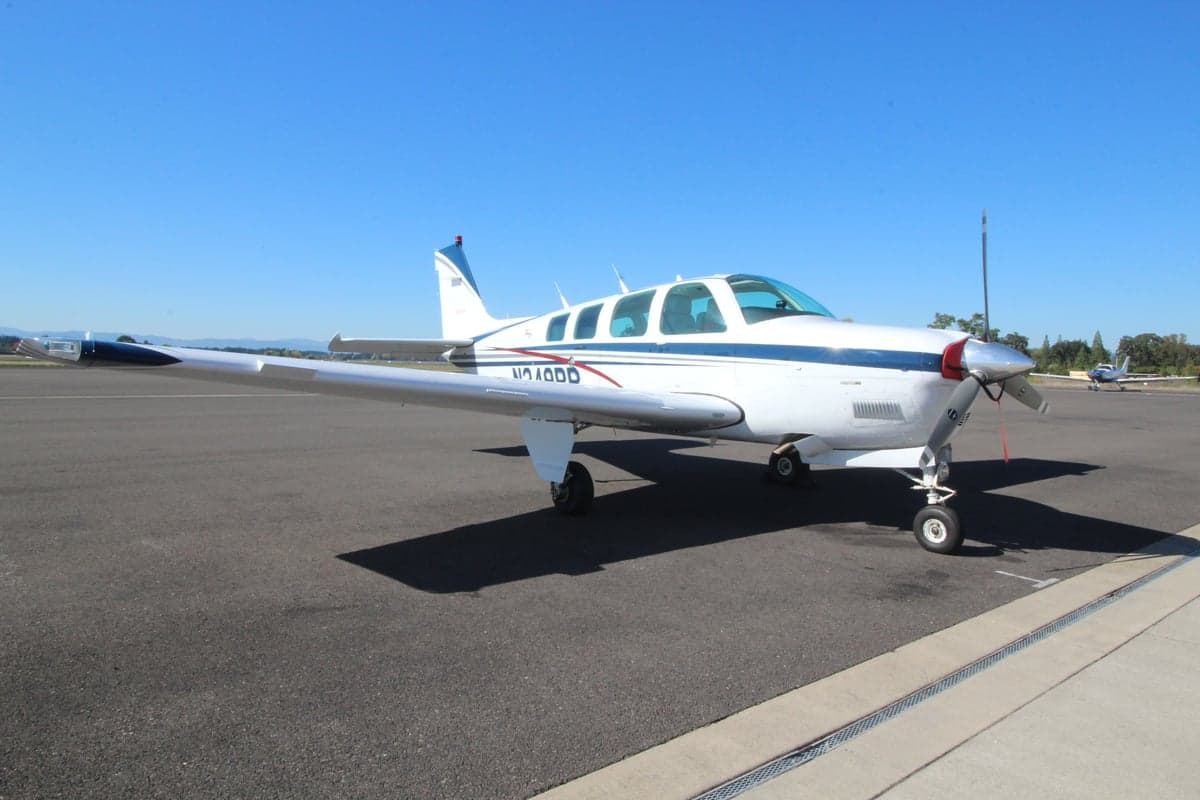 Front side view of a Beechcraft Bonanza aircraft with registration N240DD on the tarmac.