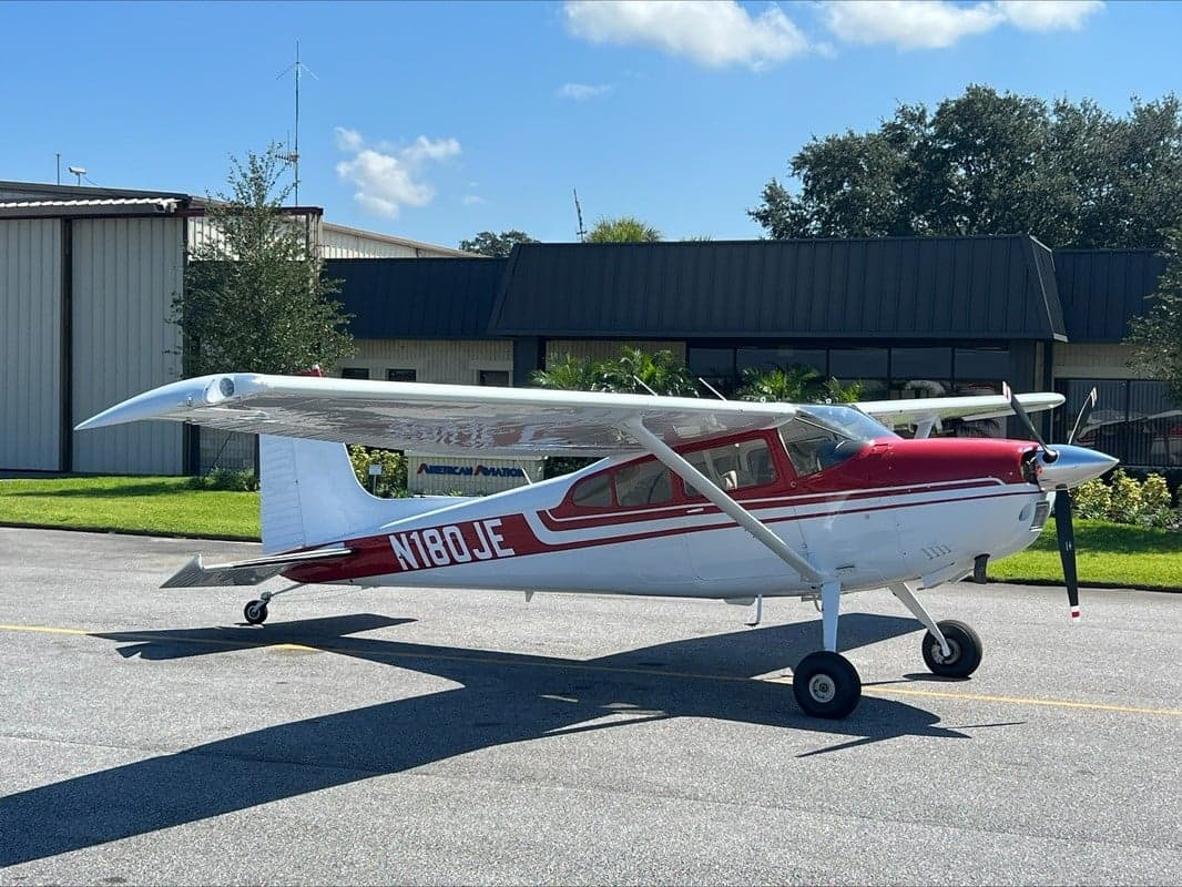 Side view of N180JE showing the red and white paint scheme.