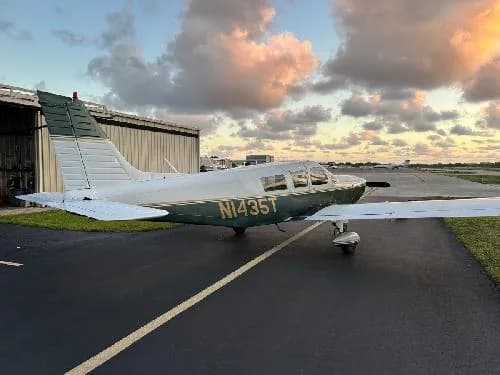 Piper PA-28-181 Archer II aircraft N1435T parked on the tarmac at sunset.