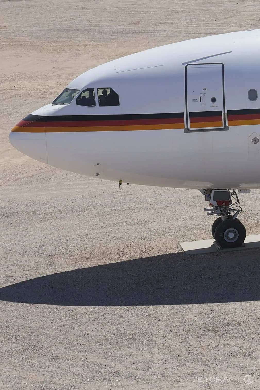 A close-up of the nose and cockpit windows of a white Airbus A340-300 with a German government livery.