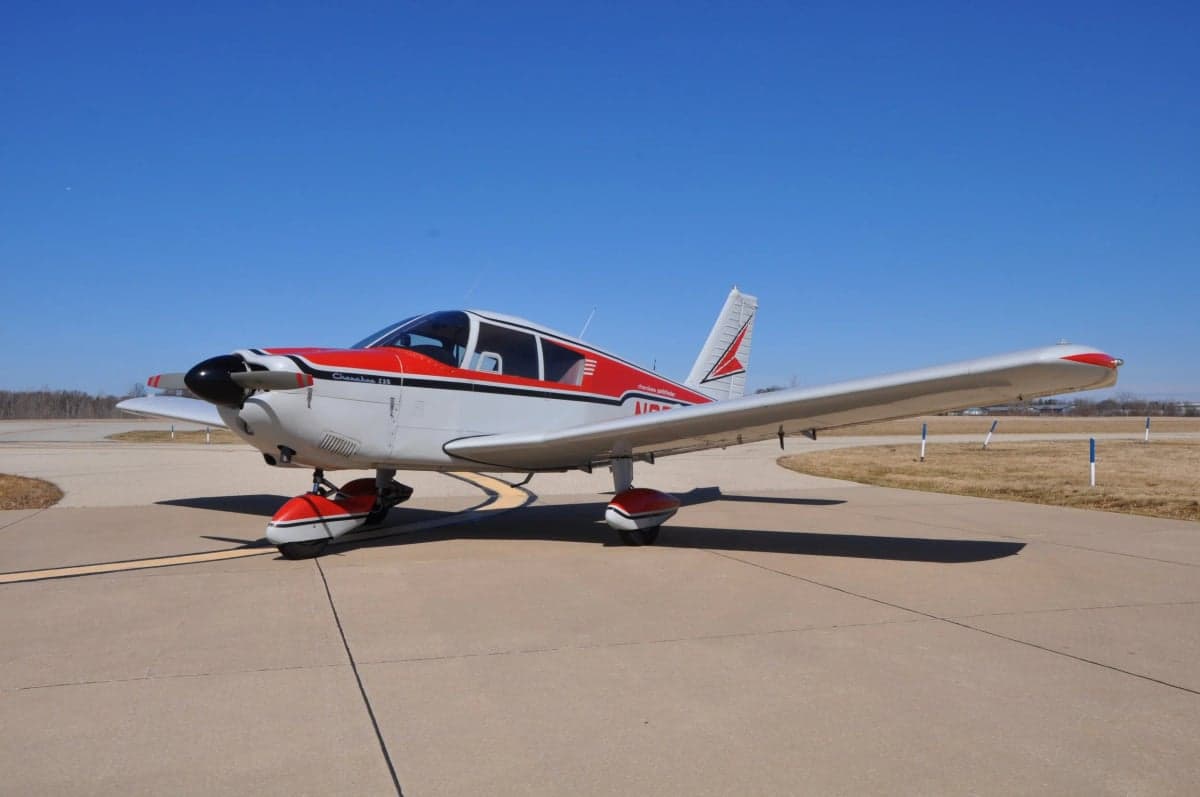 A Cherokee 180 aircraft is parked on the tarmac.