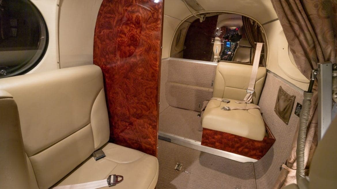Interior view of the aircraft cabin showing the seating arrangement and wood paneling.