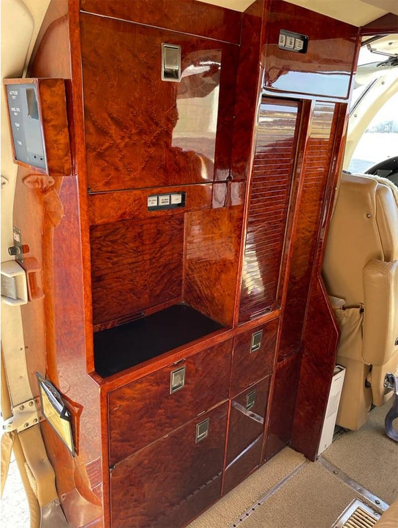 A wooden cabinet is installed in the interior of a Cessna Citation CJ3.
