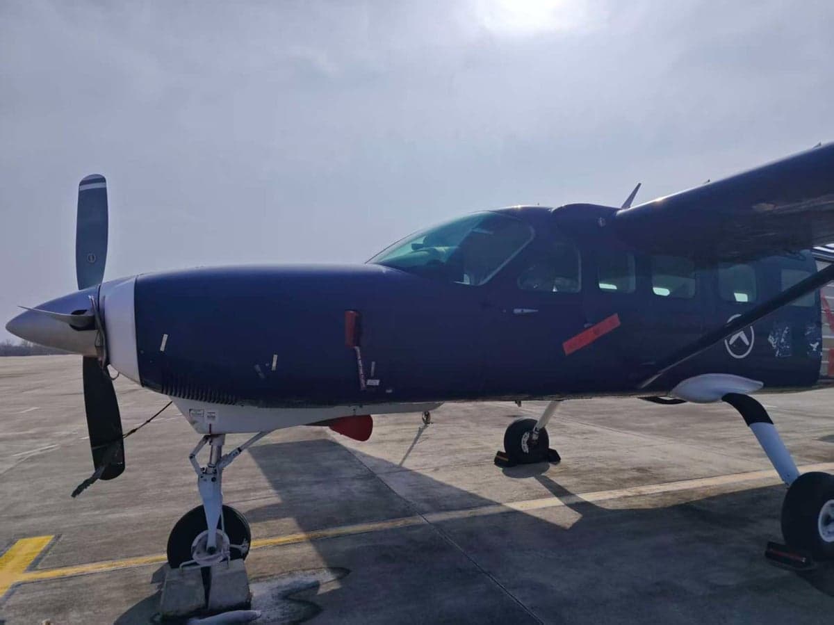 Close-up of the front of a blue aircraft on the tarmac.