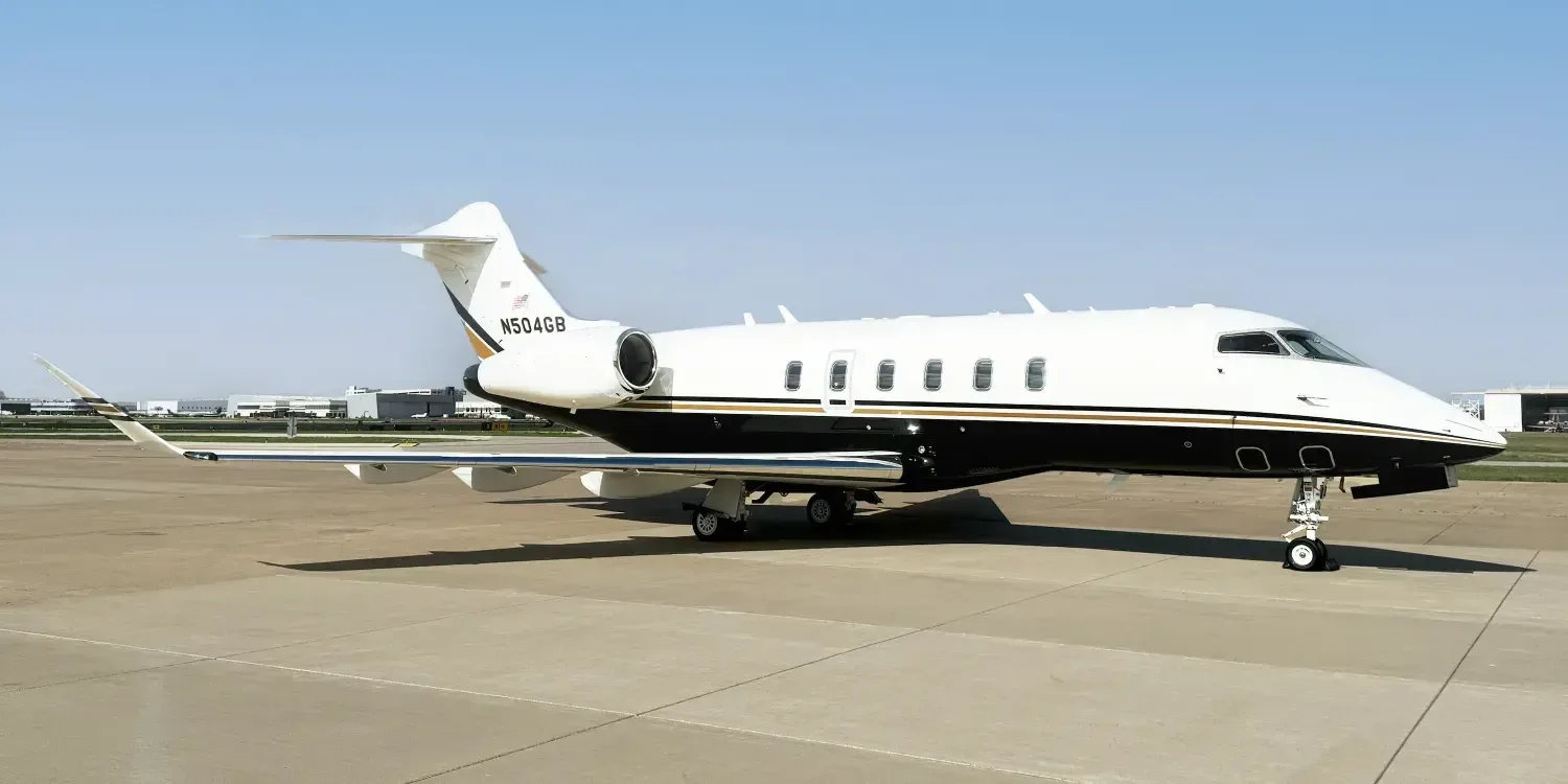 Side view of a Challenger aircraft with a white and black paint scheme on the tarmac.