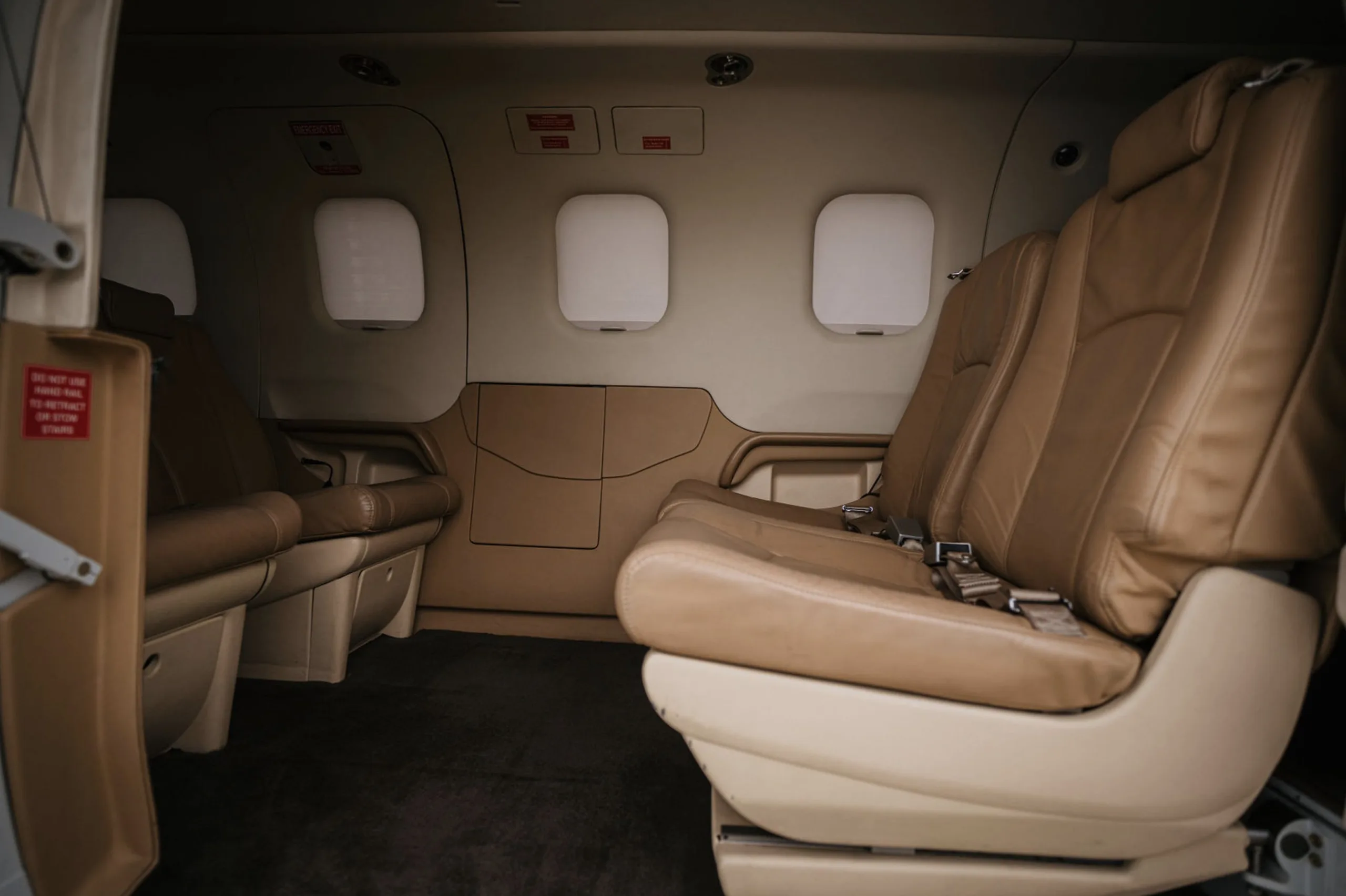 Interior view of the aircraft cabin with tan leather seats.