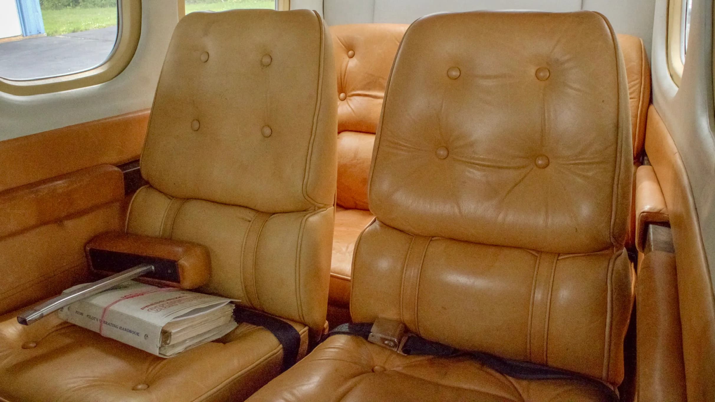 The tan leather rear passenger seats of the Cessna P210N Centurion cabin.