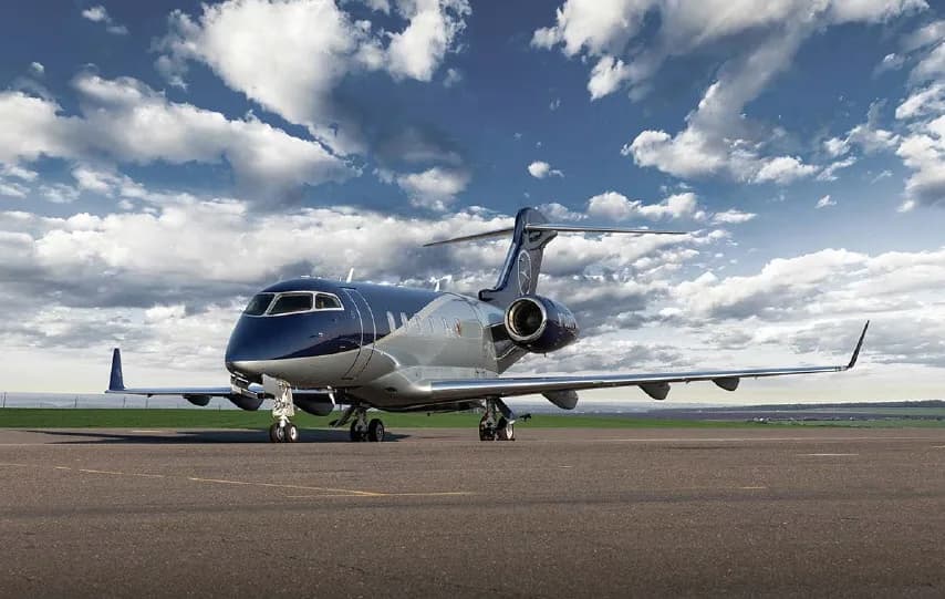 A Bombardier Challenger 350 parked on the tarmac with a blue and silver paint scheme.
