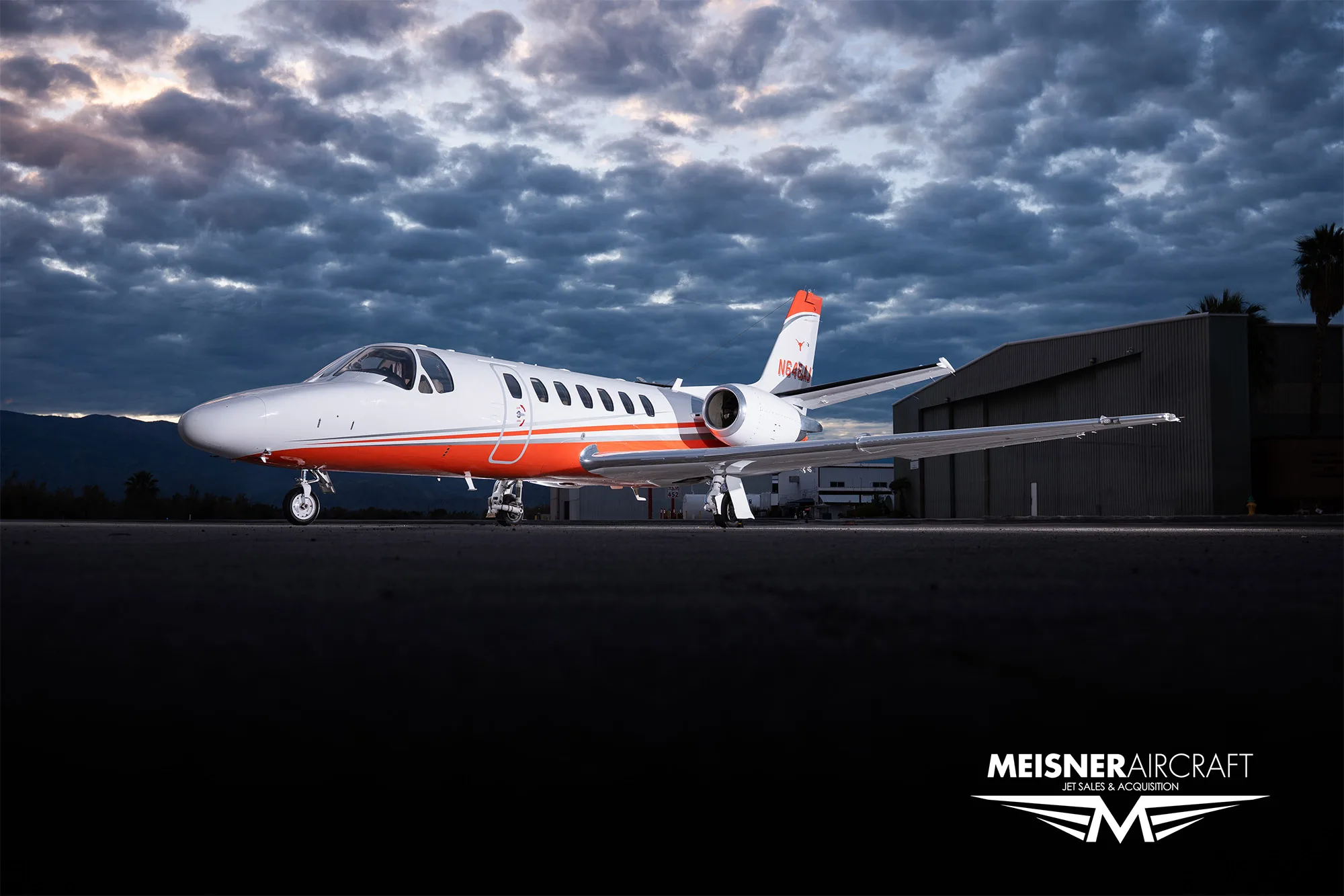 Cessna Citation Encore with orange stripe at dusk.