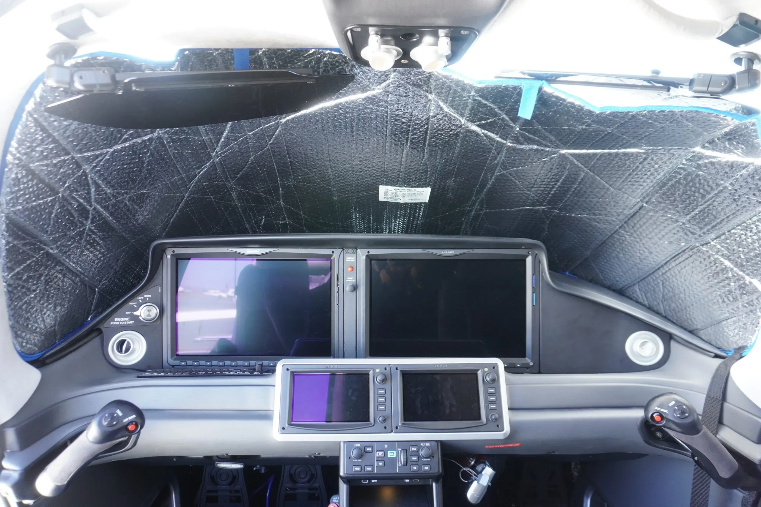 The cockpit of the aircraft features a modern glass panel display with sunshades.