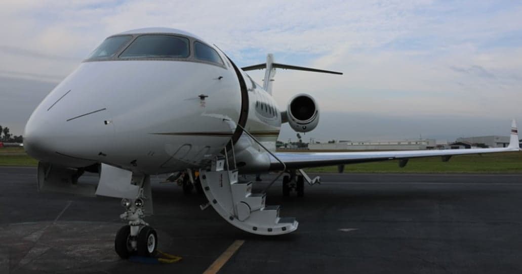 Close-up of a white jet aircraft with the airstair door open.