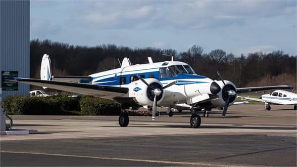Beechcraft Model 18 with registration N8495A parked on the tarmac.