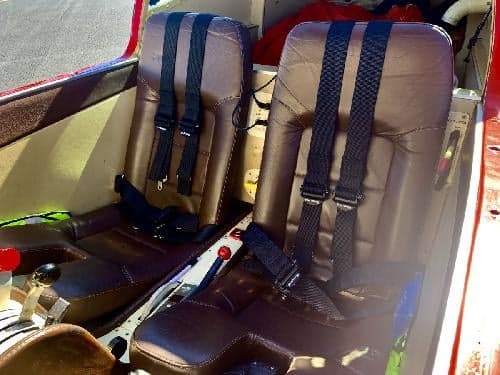 Interior view of the aircraft showing the seats and seatbelts.