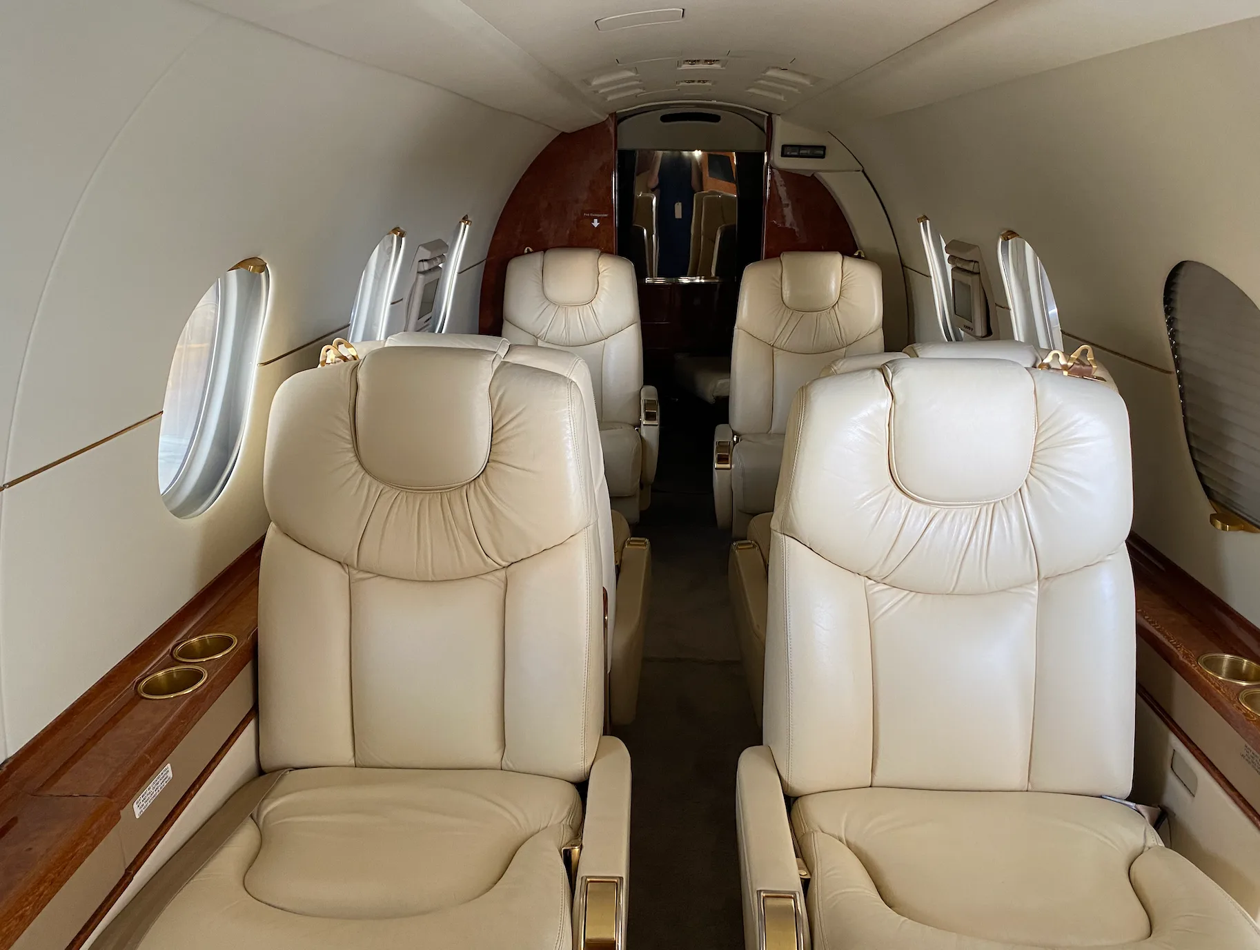 Interior view of the aircraft cabin with cream-colored leather seats.