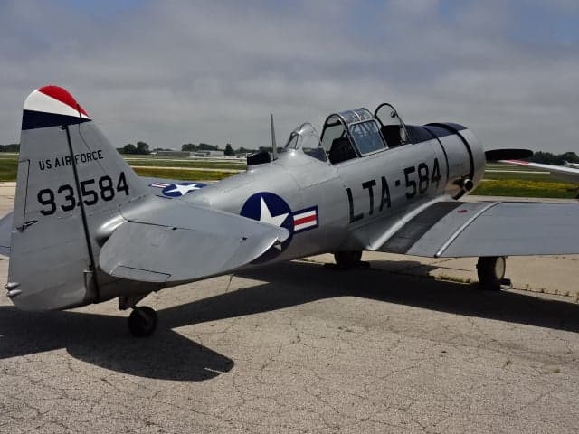 Rear quarter view of the silver T-6 Texan aircraft on the tarmac.