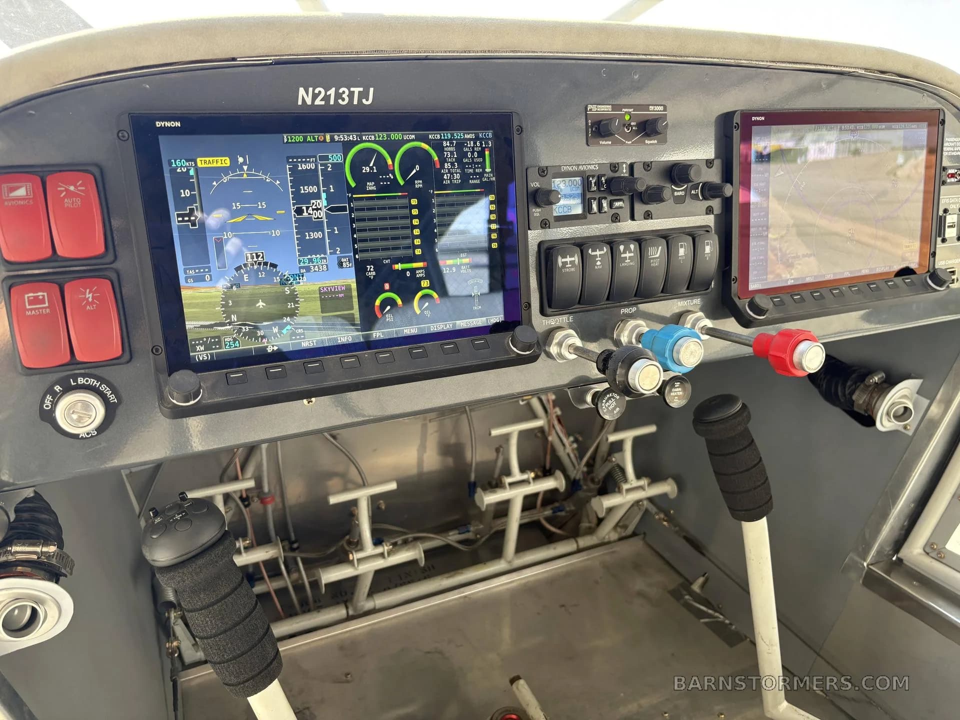 The modern cockpit of an aircraft, featuring two large digital displays showing flight information and a GPS map, along with various controls and switches.