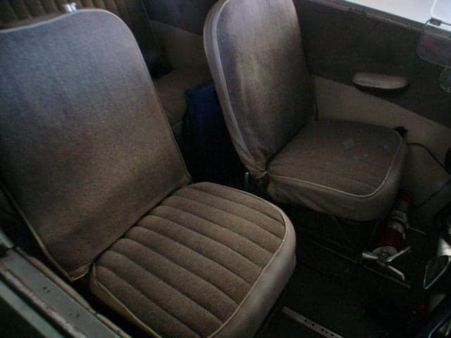 Two brown fabric front seats in the interior of a small aircraft.