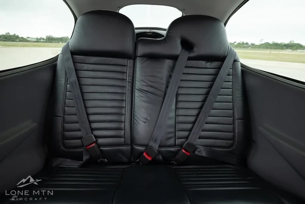 A straight-on view of the black leather rear seats in a Cirrus SR20 aircraft cabin.