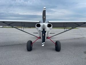 Rear view of a white aircraft on a paved surface.