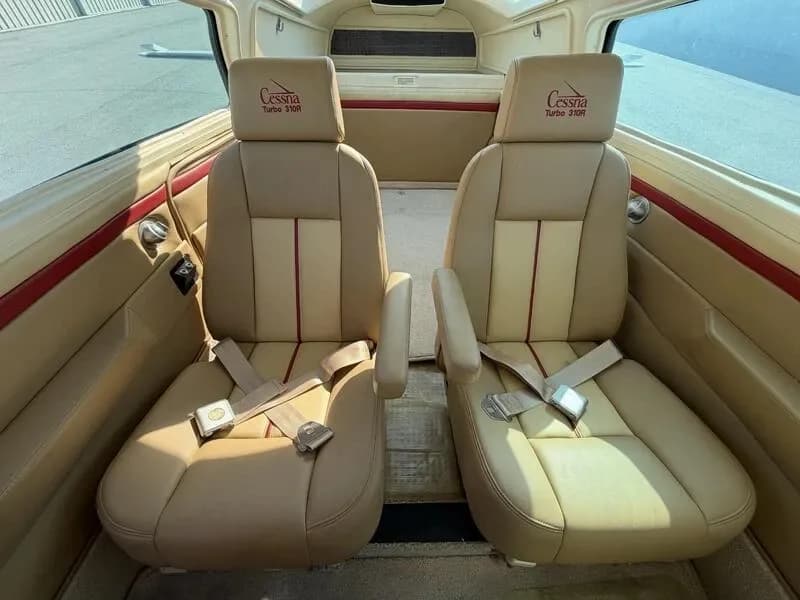 View of the tan leather rear cabin seats with "Cessna Turbo 310R" embroidered headrests.