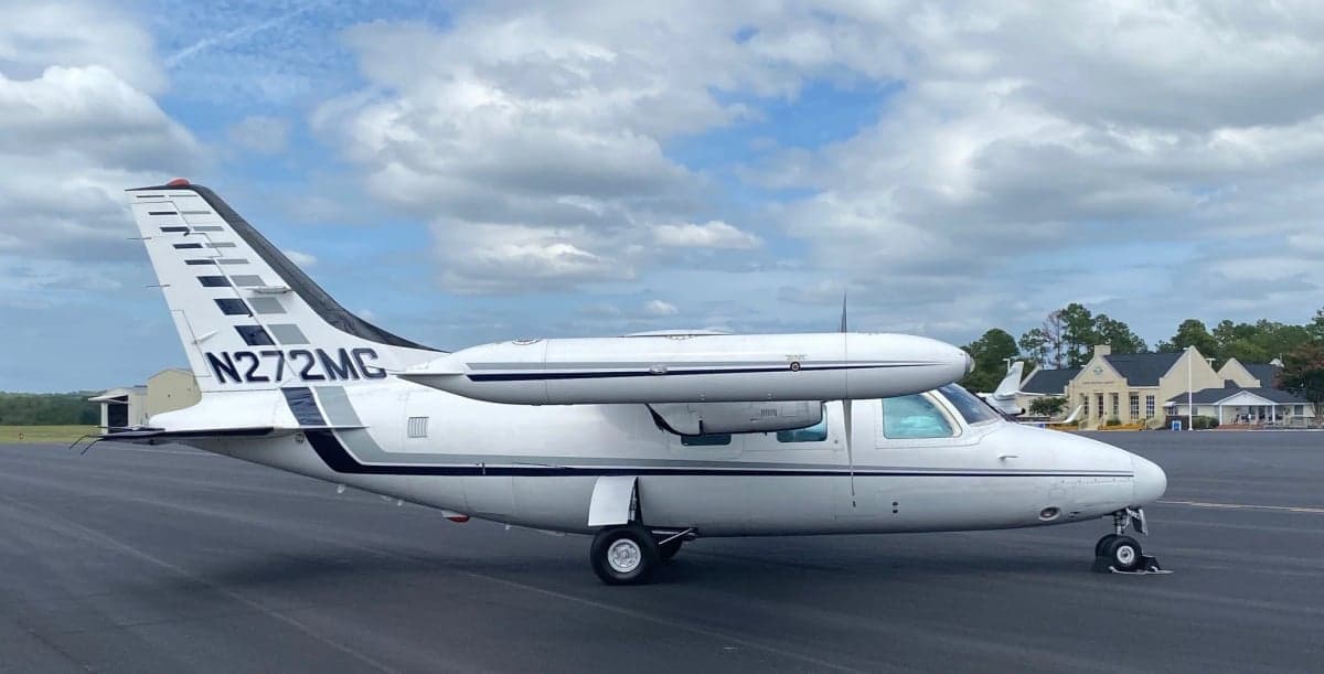 The aircraft N272MC is parked on the tarmac with a white and gray paint scheme.