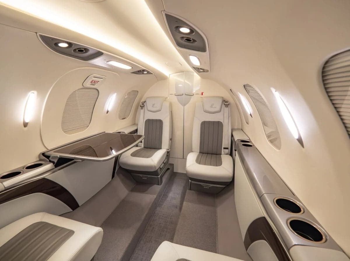 View of the interior cabin seating of the aircraft with a fold-down table.