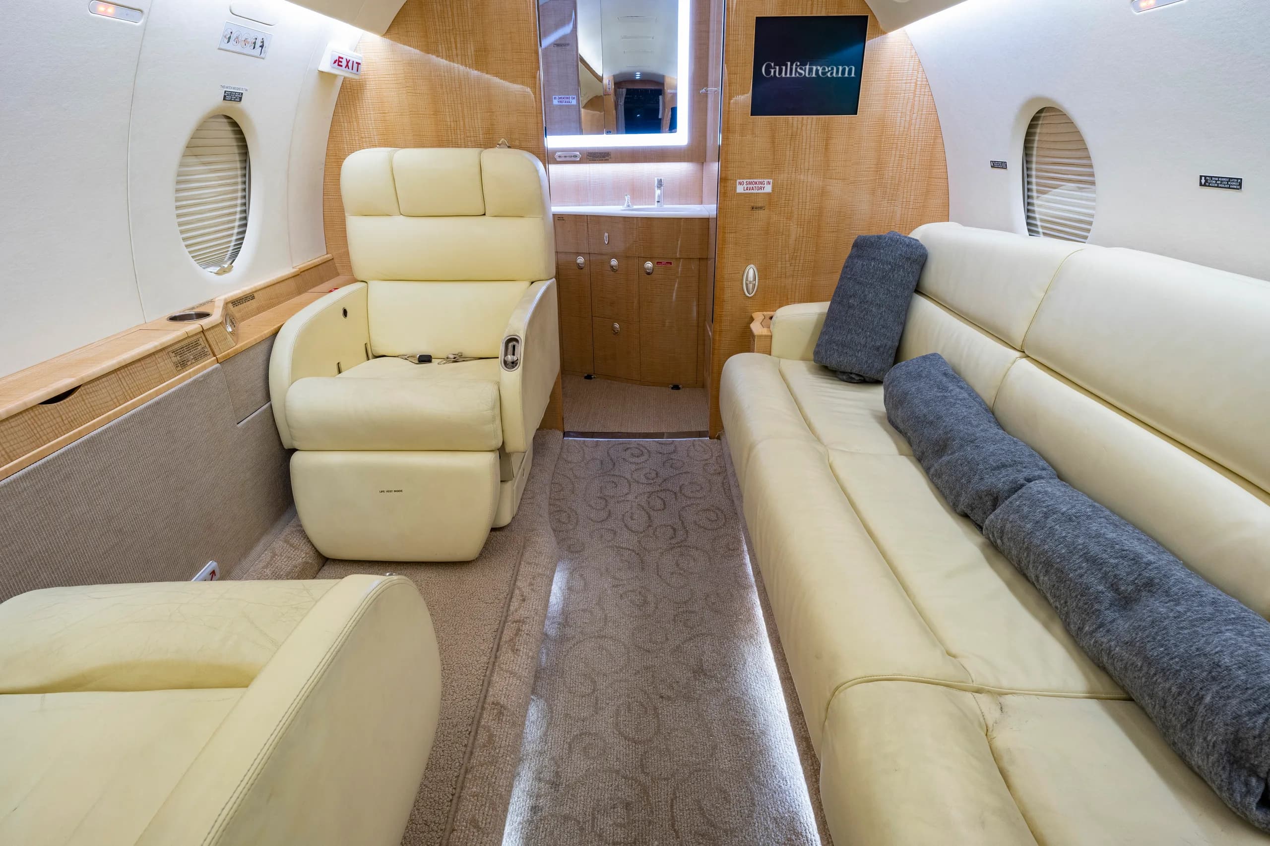 The aircraft's interior features a cream-colored leather seat and a couch.